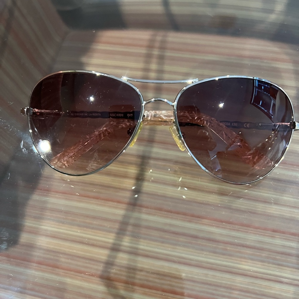 Oscar de la Renta sunglasses with silver metallic rims.
